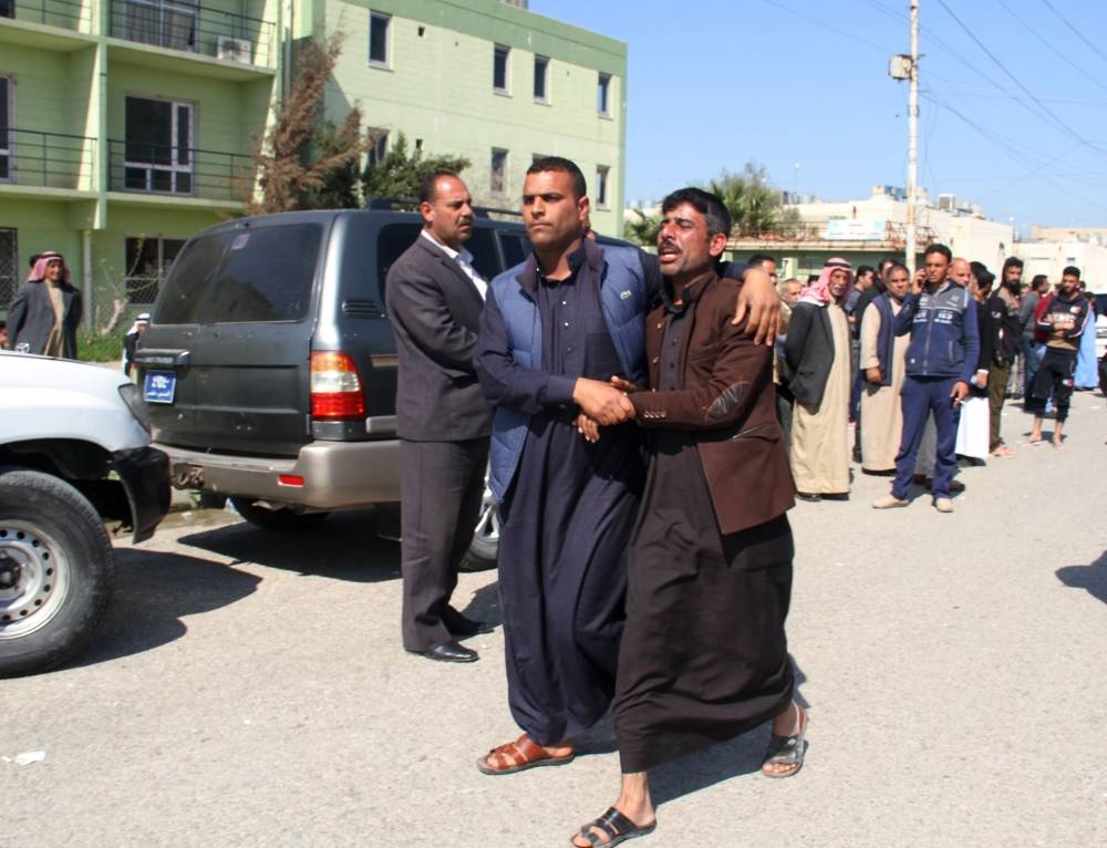 Relatives mourn the death of a passenger who died in the ferry accident while crossing Tigris river, outside a morgue in the northern Iraqi city of Mosul on March 22, 2019. The capsizing of a ferry packed with Iraqi families celebrating Kurdish New Year in Mosul left at least 100 people dead, mostly women and children, the interior ministry said Friday in a revised toll. / AFP / Waleed AL-KHALED
