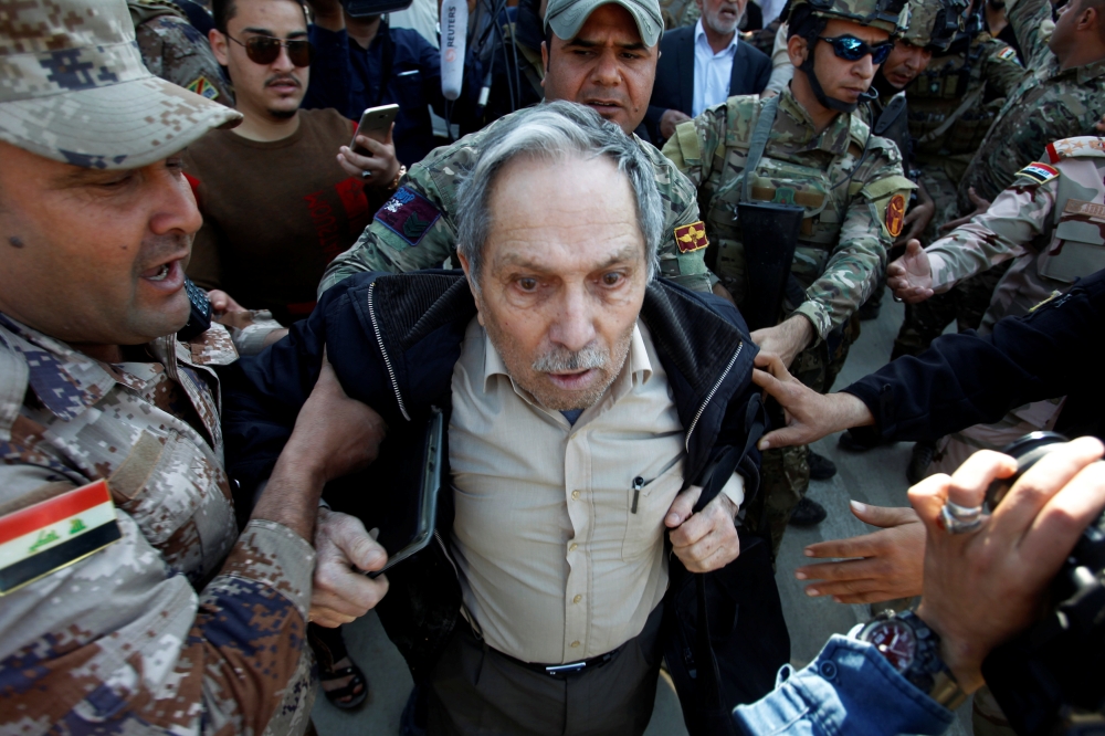 Iraqi soldiers take away a protester, relative of victims drowned after an overloaded ferry sank in Tigris river, who attacked Iraqi President Barham Salih's motorcade during his visit to the scene, in Mosul, Iraq March 22, 2019. REUTERS/Khalid al-Mousily