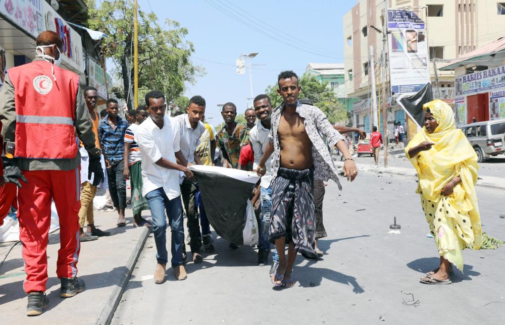 





 مدنيون يحملون جثة أحد قتلى العملية الإرهابية في العاصمة الصومالية مقديشو، أمس. (رويترز)
