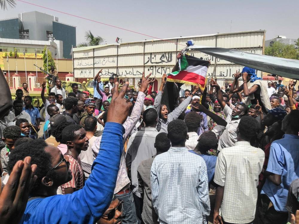 Sudanese protesters chant slogans as they rally for a fifth day in front of the military headquarters in the capital Khartoum on April 10, 2019. Thousands of protesters have been camping outside the military complex housing Bashir's official residence in Khartoum since April 6, braving tear gas and deadly gun shots from security services in defiance of a state of emergency banning all such demonstrations. The army, which has steered clear of intervening in the clashes since the start of the anti-government protests in December, has so far stood on the sidelines. / AFP / -
