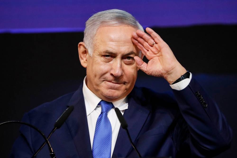 TOPSHOT - Israeli Prime Minister Benjamin Netanyahu gestures as he addresses supporters at his Likud Party headquarters in the Israeli coastal city of Tel Aviv on election night early on April 10, 2019. / AFP / Thomas COEX
