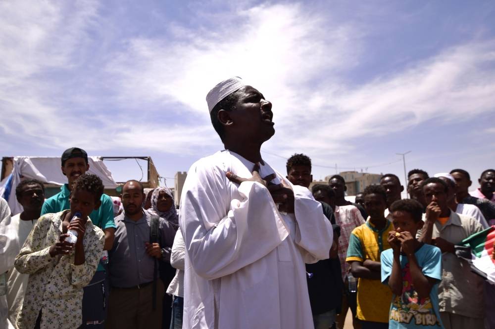 A demonstrator chants slogans as protesters gather in the Sudanese capital Khartoum, on April 14, 2019. Sudanese protest organisers have presented demands to the country's new military rulers, urging the creation of a civilian government, the group spearheading demonstrations said. / AFP / AHMED MUSTAFA 