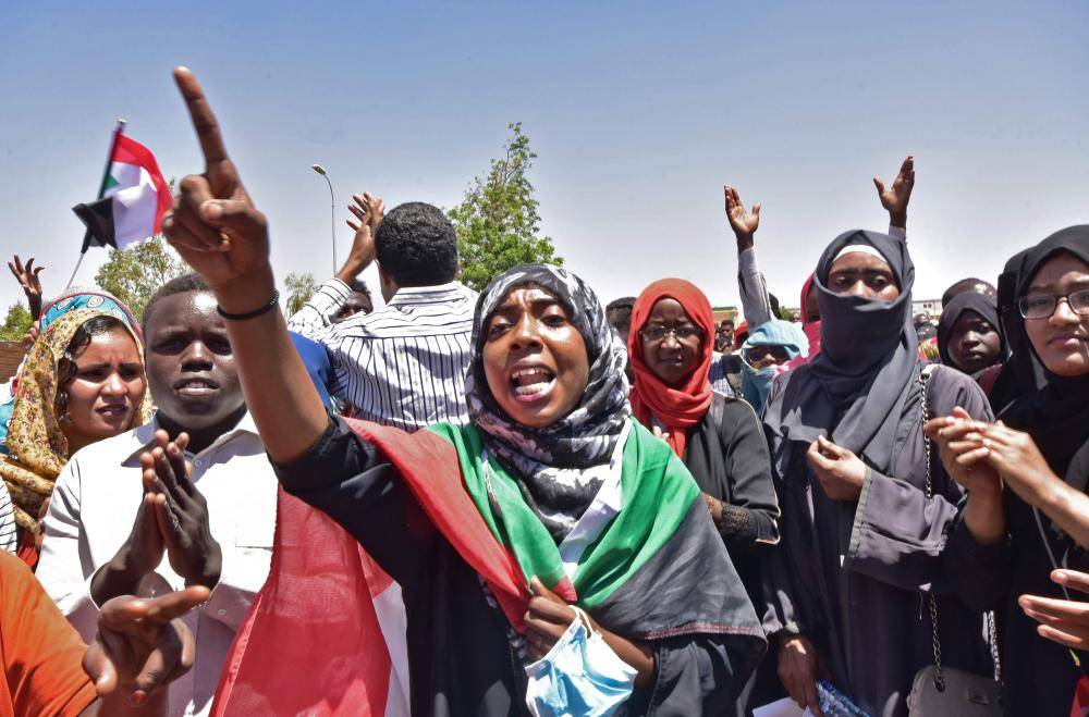 



 سودانية تلتحف بعلم بلادها وتهتف بشعارات رافضة لفضّ الاعتصام أمام مقر القيادة العسكرية في الخرطوم أمس.  (أ.ف.ب)
