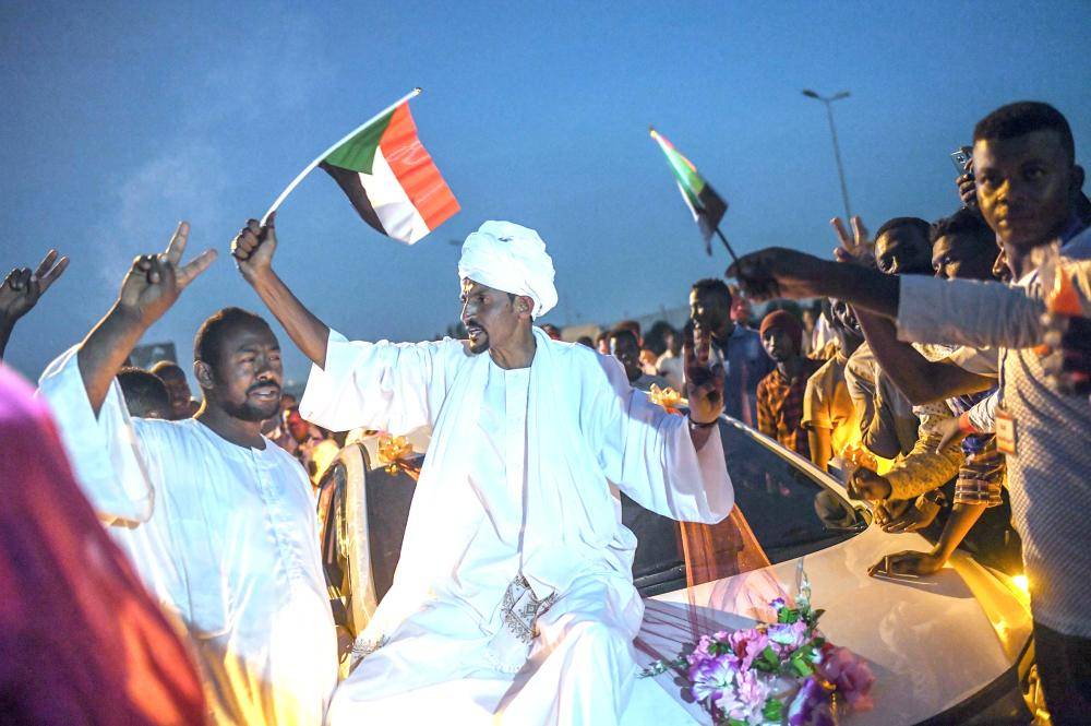 



سودانيون يرفعون العلم الوطني على سيارة زفاف خلال مظاهرة خارج مجمع الجيش الخرطوم أمس الأول. (أ.ف.ب)