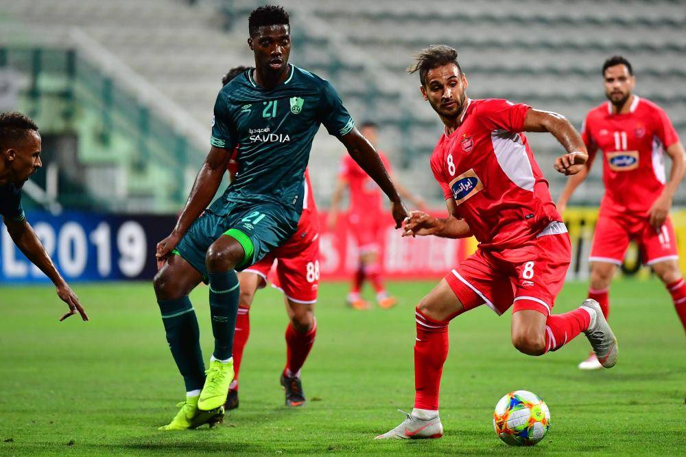 Persepolis' Ahmad Noorollah (R) fights for the ball with Al Ahli's Jorge Semedo during the AFC Champions League group D football match between Saudi's Al Ahli and Iran's Persepolis at the Maktoum Bin Rashid Al Maktoum Stadium in Dubai on April 22, 2019.
 / AFP / Giuseppe CACACE
