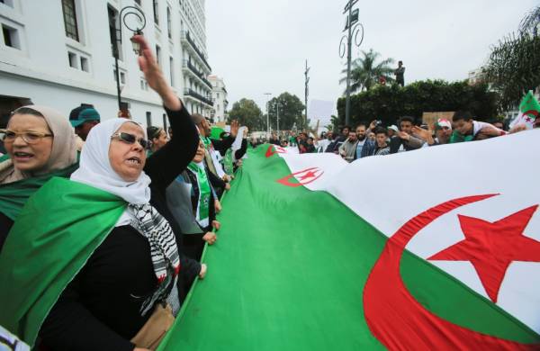 Demonstrators hold a flag and banners during an anti-government protest in Algiers, Algeria May 3, 2019. REUTERS/Ramzi Boudina