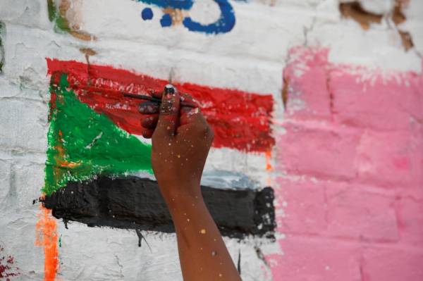 Amna Almahi works on a mural near the defence ministry compound in Khartoum, Sudan, April 22, 2019. Picture taken April 22, 2019. REUTERS/Umit Bektas