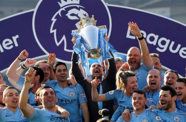 Soccer Football - Premier League - Brighton & Hove Albion v Manchester City - The American Express Community Stadium, Brighton, Britain - May 12, 2019  Manchester City manager Pep Guardiola lifts the trophy as they celebrate winning the Premier League               REUTERS/Toby Melville  EDITORIAL USE ONLY. No use with unauthorized audio, video, data, fixture lists, club/league logos or 