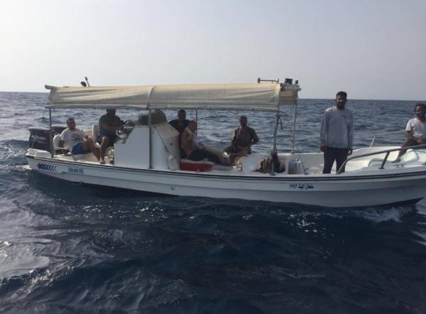الأشخاص الثمانية في القارب قبل إنقاذهم.
