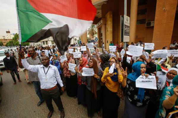 Employees demonstrate outside Bank of Khartoum on May 28, 2019 as they participate in a two-day national strike to step up pressure on the ruling military council. Thousands of Sudanese employees in government offices, private companies and the economic hub of Port Sudan began a two-day national strike after Sudanese protest leaders piled pressure on the military to hand power to a civilian administration. / AFP / ASHRAF SHAZLY 