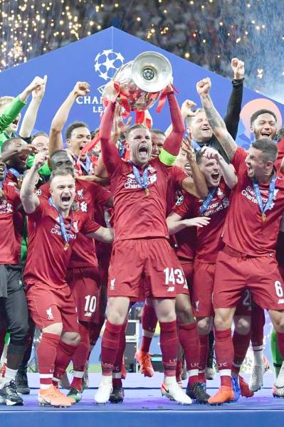 Liverpool's English midfielder Jordan Henderson raises the trophy after winning the UEFA Champions League final football match between Liverpool and Tottenham Hotspur at the Wanda Metropolitano Stadium in Madrid on June 1, 2019. / AFP / Ben STANSALL
