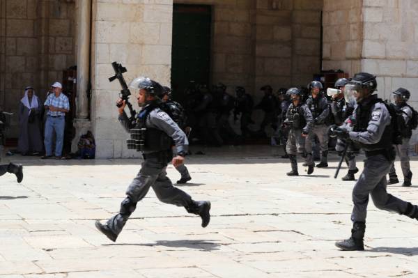 Israeli policemen run with their weapons during clashes with Palestinians on «Jerusalem Day» on the compound known to Muslims as Noble Sanctuary and to Jews as Temple Mount, in Jerusalem's Old City June 2, 2019. REUTERS/Ammar Awad