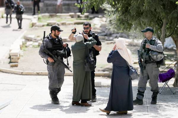 



 فلسطينية تصرخ في وجه شرطي إسرائيلي عقب اندلاع مواجهات احتجاجا على تدنيس متطرفين المسجد الأقصى أمس. (رويترز)