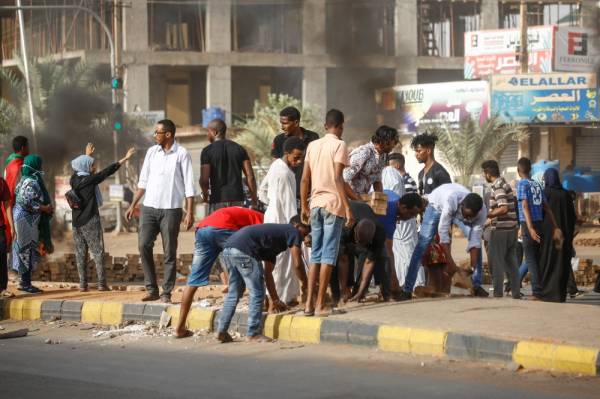 Sudanese protesters remove pavers to block the road as military forces tried to disperse the sit-in outside Khartoum's army headquarters on June 3, 2019. At least two people were killed Monday as Sudan's military council tried to break up a sit-in outside Khartoum's army headquarters, a doctors' committee said as gunfire was heard from the protest site.
 / AFP / ASHRAF SHAZLY
