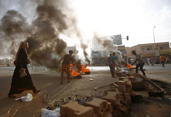 Sudanese protesters block Street 60 with burning tyres and paving stones as the military forces tried to disperse the sit-in outside Khartoum's army headquarters on June 3, 2019. At least two people were killed Monday as Sudan's military council tried to break up a sit-in outside Khartoum's army headquarters, a doctors' committee said as gunfire was heard from the protest site.
 / AFP / ASHRAF SHAZLY
