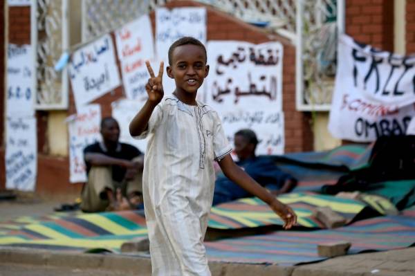 A Sudanese boy flashes the v for victory sign in Khartoum on June 2, 2019. The military ousted president Omar al-Bashir in April after months of protests against his authoritarian rule. Protesters have remained camped out in front of Khartoum's army headquarters to pressure the generals to yield power. Negotiations between protest leaders and the ruling military council have broken down, as the two sides have failed to agree on whether a planned transitional body would be headed by a civilian or a military figure. / AFP / ASHRAF SHAZLY
