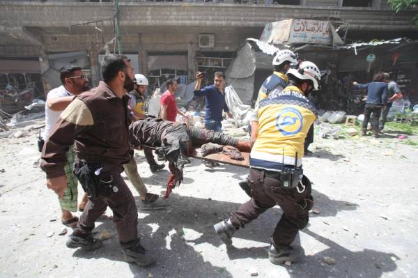 EDITORS NOTE: Graphic content / Members of the Syrian Civil Defence (known as the White Helmets) carry a wounded man on a stretcher following a reported air strike on the town of Maaret al-Numan in the jihadist-held Idlib province on June 3, 2019. / AFP / Abdulaziz KETAZ
