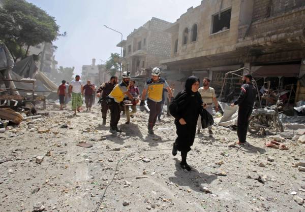 EDITORS NOTE: Graphic content / Members of the Syrian Civil Defence (known as the White Helmets) carry a wounded man on a stretcher following a reported air strike on the town of Maaret al-Numan in the jihadist-held Idlib province on June 3, 2019. / AFP / Abdulaziz KETAZ
