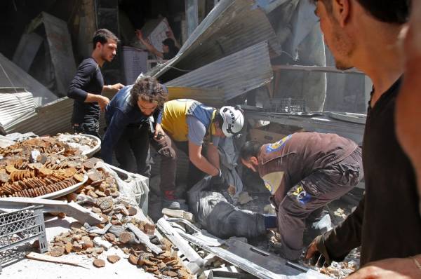 Members of the Syrian Civil Defence (known as the White Helmets) evacuate a wounded man from under the rubble following a reported air strike on the town of Maaret al-Numan in the jihadist-held Idlib province on June 3, 2019. / AFP / Abdulaziz KETAZ
