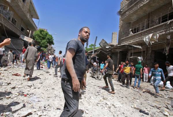 Syrians gather at the site of a reported air strike on the town of Maaret al-Numan in the jihadist-held Idlib province on June 3, 2019. / AFP / Abdulaziz KETAZ
