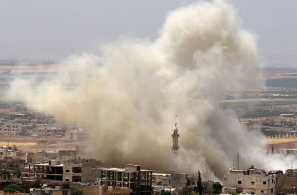 TOPSHOT - Smoke plumes following reported airstrikes on the town of Khan Sheikhun in the southern countryside of the rebel-held Idlib province on June 3, 2019. / AFP / Anas AL-DYAB
