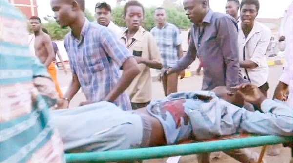 CORRECTION / An image grab taken from a video posted on Ahmed Kwarte's Facebook page shows Sudanese protesters carrying a wounded demonstrator during confrontation with security forces near Khartoum's army headquarters on June 3, 2019. Sudan's military on June 4 cancelled a power-transfer agreement with protesters and called for elections within nine months, a day after more than 35 demonstrators were killed in what they called a «bloody massacre». - 
 / AFP / -
