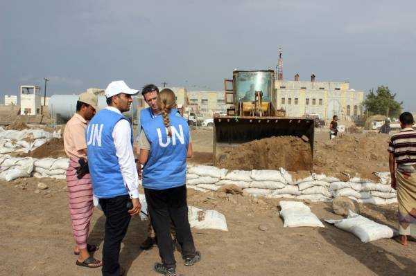 Members of United Nations Mission in support of the Hodeida Agreement (UNMHA) monitor the removal of sandbag barricades in the embattled Yemeni Red Sea port city of Hodeida on June 3, 2019.  / AFP / STR
