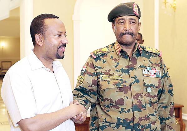 Ethiopia's Prime Minister Abiy Ahmed (L) meets with the chief of Sudan's ruling military council General Abdel Fattah al-Burhan in Khartoum on June 7, 2019. Ethiopia's prime minister arrived in Khartoum today seeking to broker talks between the ruling generals and protesters as heavily armed paramilitaries remained deployed in some squares of the Sudanese capital after a deadly crackdown, leaving residents in 'terror'. / AFP / ASHRAF SHAZLY
