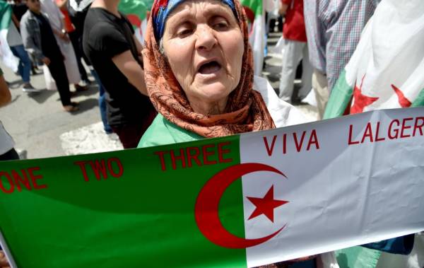 An elderly Algerian protester holds the national flag during a demonstration in the capital Algiers on June 7, 2019. Interim Algerian president Abdelkader Bensalah on June 6 called for «dialogue» after the authorities ruled out holding a planned election on July 4. / AFP / RYAD KRAMDI 
