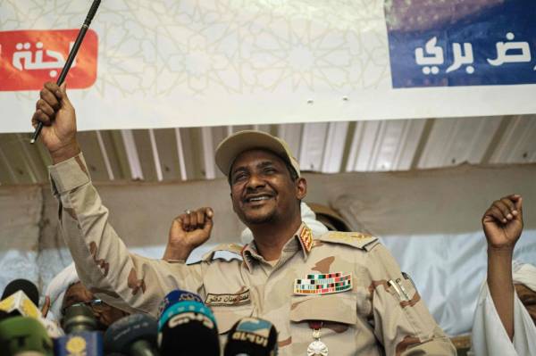 Sudanese General Mohamed Hamdan Dagalo, also known as Himediti, deputy head of Sudan's ruling Transitional Military Council (TMC) and commander of the Rapid Support Forces (RSF) paramilitaries, raises up a stick during a meeting with his supporters in the capital Khartoum on June 18, 2019. / AFP / Yasuyoshi CHIBA 