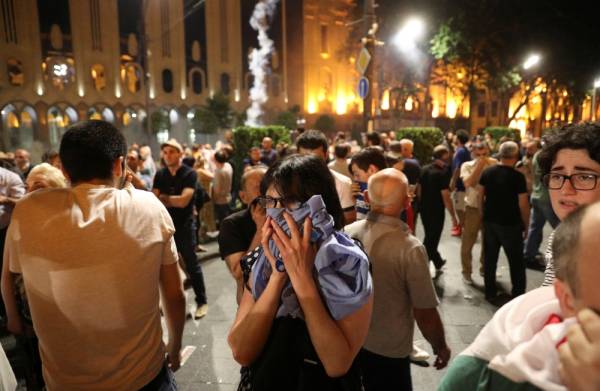 People cover faces to protect themselves from tear gas used by police during a protest against a Russian lawmaker's visit in Tbilisi, Georgia June 20, 2019. REUTERS/Irakli Gedenidze