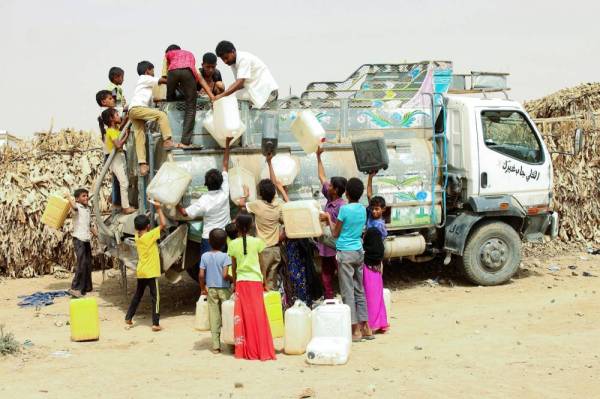 



نازحون يمنيون من الحديدة يحصلون على الماء في مخيم بمديرية عبس في حجة أمس الأول. (أ.ف.ب)