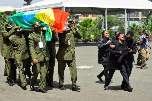 People mourn as members of the army carry one of the coffins covered with the Ethiopian national flag as they arrive at the millennium hole in Addis Ababa, on June 25, 2019 for the National funeral service of Chief of Staff of the Ethiopian defence forces Seare Mekonnen and of Major-General Geza'e Abera, a retired former senior official in the Ethiopian army. Ethiopian military and religious leaders condemned, on June 25, 2019, the assassinations of the army chief and other top officials at an emotional funeral service at which Prime Minister Abiy Ahmed wept openly throughout. / AFP / Michael TEWELDE 