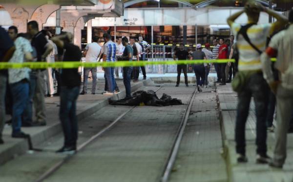 EDITORS NOTE: Graphic content / TOPSHOT - Onlookers gather at the scene outside a metro station where a man reportedly wearing an explosive belt blew himself up in the early hours of July 3, 2019 in the capital Tunis, after being chased by police.

 The Tunisian interior ministry said a jihadist, on the run for two days, was killed on July 3 in the western Tunis neighbourhood of Cité Intilaka while security forces were chasing him to detain him. The official sources said the suspect blew himself up during the police operation. / AFP / -
