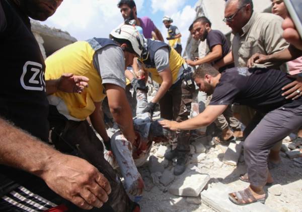 EDITORS NOTE: Graphic content / Syrian rescuers and civilians pull a man from the rubble of a building following an airstrike by Syrian regime forces in Maar Shurin on the outskirts of Maaret al-Numan in northwest Syria on July 16, 2019. Regime airstrikes today killed nine civilians in rebel-held northwest Syria, the target of months of regime and Russian bombardment, war monitor the Syrian Observatory for Human Rights said. / AFP / Abdulaziz KETAZ 