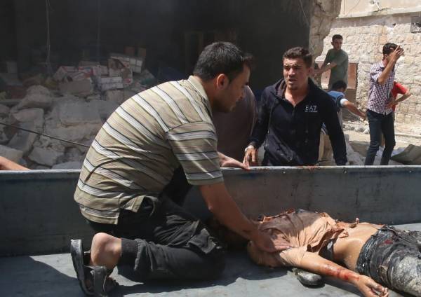 EDITORS NOTE: Graphic content / Syrian civilians evacuate a wounded man following an airstrike by Syrian regime forces in Maar Shurin on the outskirts of Maaret al-Numan in northwest Syria on July 16, 2019. Regime airstrikes today killed nine civilians in rebel-held northwest Syria, the target of months of regime and Russian bombardment, war monitor the Syrian Observatory for Human Rights said. / AFP / Abdulaziz KETAZ 