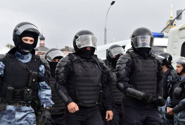 Riot police officers and servicemen of the Russian National Guard are seen during an unsanctioned rally urging fair elections in downtown Moscow on August 3, 2019. The rally is the latest in a series of demonstrations after officials refused to let popular opposition candidates run in next month's city parliament elections. / AFP / Vasily MAXIMOV 
