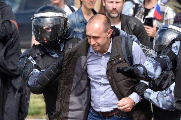 Servicemen of the Russian National Guard detain a man during an unsanctioned rally urging fair elections in downtown Moscow on August 3, 2019. The rally is the latest in a series of demonstrations after officials refused to let popular opposition candidates run in next month's city parliament elections. / AFP / Vasily MAXIMOV 
