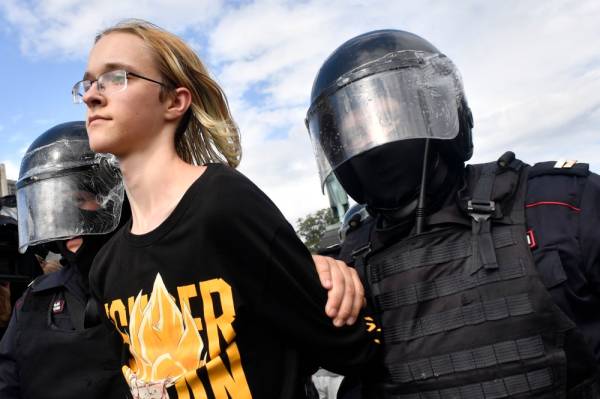 Riot police officers detain a participant of an unsanctioned rally urging fair elections at Moscow's Pushkinskaya Square on August 3, 2019. The rally is the latest in a series of demonstrations after officials refused to let popular opposition candidates run in next month's city parliament elections. / AFP / Alexander NEMENOV
