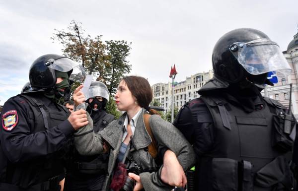 Riot police officers detain a journalist during an unsanctioned rally urging fair elections at Moscow's Pushkinskaya Square on August 3, 2019. The rally is the latest in a series of demonstrations after officials refused to let popular opposition candidates run in next month's city parliament elections. / AFP / Alexander NEMENOV
