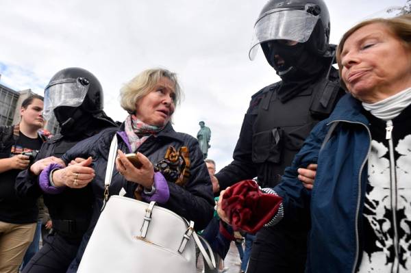 Riot police officers detain women during an unsanctioned rally urging fair elections at Moscow's Pushkinskaya Square on August 3, 2019. The rally is the latest in a series of demonstrations after officials refused to let popular opposition candidates run in next month's city parliament elections. / AFP / Alexander NEMENOV
