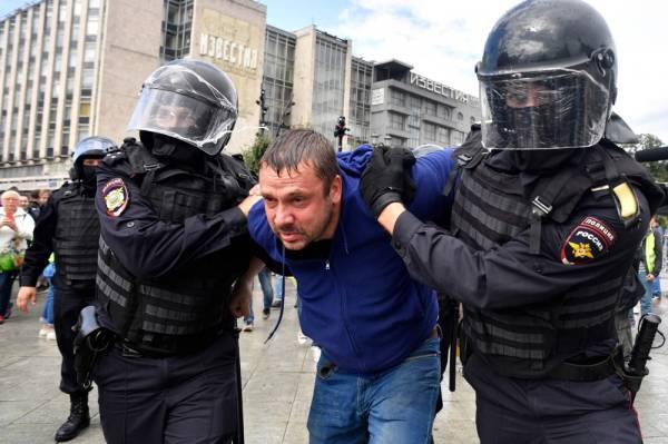 Riot police officers detain a participant of an unsanctioned rally urging fair elections at Moscow's Pushkinskaya Square on August 3, 2019. The rally is the latest in a series of demonstrations after officials refused to let popular opposition candidates run in next month's city parliament elections. / AFP / Alexander NEMENOV
