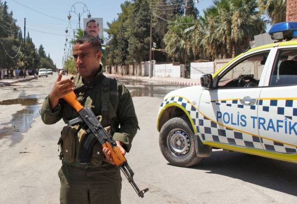 A member of the Kurdish security stands guard at the site of a explosive-rigged vehicle that detonated in the town of al-Qahtaniyah, in the Hasakeh province on August 7, 2019. A car bombing claimed by the Islamic State group killed five people, including three children, in a Kurdish-held town in northeast Syria on Wednesday, a war monitor said. / AFP / Muhammad AHMAD
