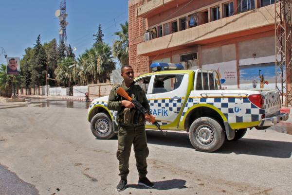 A member of the Kurdish security stands guard at the site of a explosive-rigged vehicle that detonated in the town of al-Qahtaniyah, in the Hasakeh province on August 7, 2019. A car bombing claimed by the Islamic State group killed five people, including three children, in a Kurdish-held town in northeast Syria on Wednesday, a war monitor said. / AFP / Muhammad AHMAD
