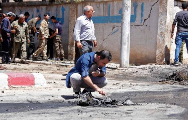 A member of the Kurdish security examines debris at the site of a explosive-rigged vehicle that detonated in the town of al-Qahtaniyah, in the Hasakeh province on August 7, 2019. A car bombing claimed by the Islamic State group killed five people, including three children, in a Kurdish-held town in northeast Syria on Wednesday, a war monitor said. / AFP / Muhammad AHMAD
