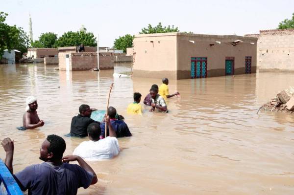 



سودانيون يحاولون الوصول لمنازلهم التي أغرقتها مياه الفيضانات وخلفت 62 قتيلا و100 مصاب على الضفة الشرقية لنهر النيل أمس الأول. (‏أ ف ب)