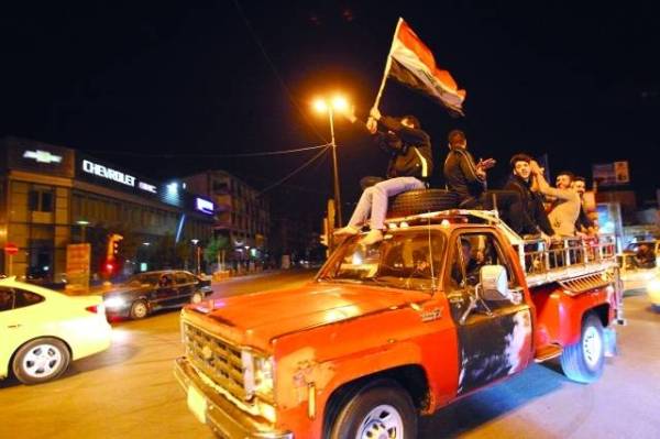 TO GO WITH AFP STORY by W.G. Dunlop, Iraq-Syria-conflict-US-Baghdad-curfewIraqis celebrate on February 8, 2015, the lift of curfew in central Baghdad. Iraqis roared through central Baghdad in dozens of cars flying flags, honking horns and filling the street with smoke from their screeching tyres to celebrate the end of a years-old nightly curfew. «Long live Iraq!», one young man shouted while hanging out the window of a passing car early on Sunday morning. It was the first night in years that Baghdad residents could stay out as late as they wished, after Iraqi premier Haider al-Abadi ordered an end to the long-running curfew that had most recently lasted from midnight to 5:00 am (1800 to 0200 GMT). AFP PHOTOALI AL-SAADI