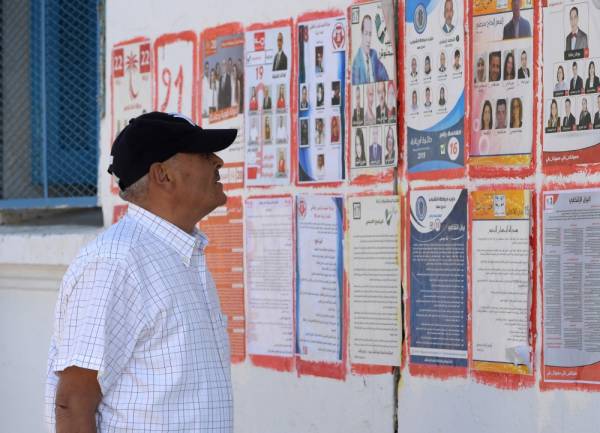 A Tunisian man looks at posters of legislatives' candidates in the capital Tunis, on October 4, 2019.
 Millions of Tunisians will head to the ballot box on October 6 to elect their parliamentary representatives in a key vote overshadowed by presidential polls. / AFP / FETHI BELAID
