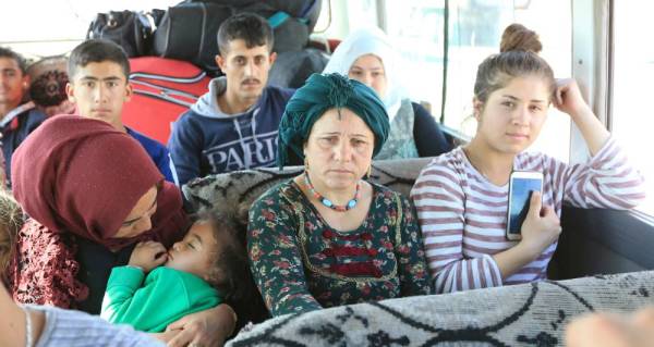 Syrian displaced families, who fled violence after the Turkish offensive against Syria, sit in a bus on their way to camps on the outskirts of Dohuk, Iraq October 16, 2019. REUTERS/Ari Jalal