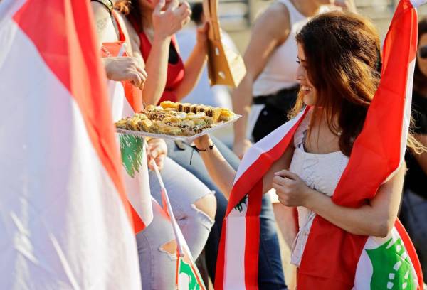 متظاهرة لبنانية تقدم الحلويات للمحتجين خلال الانتفاضة الشعبية شمالي بيروت